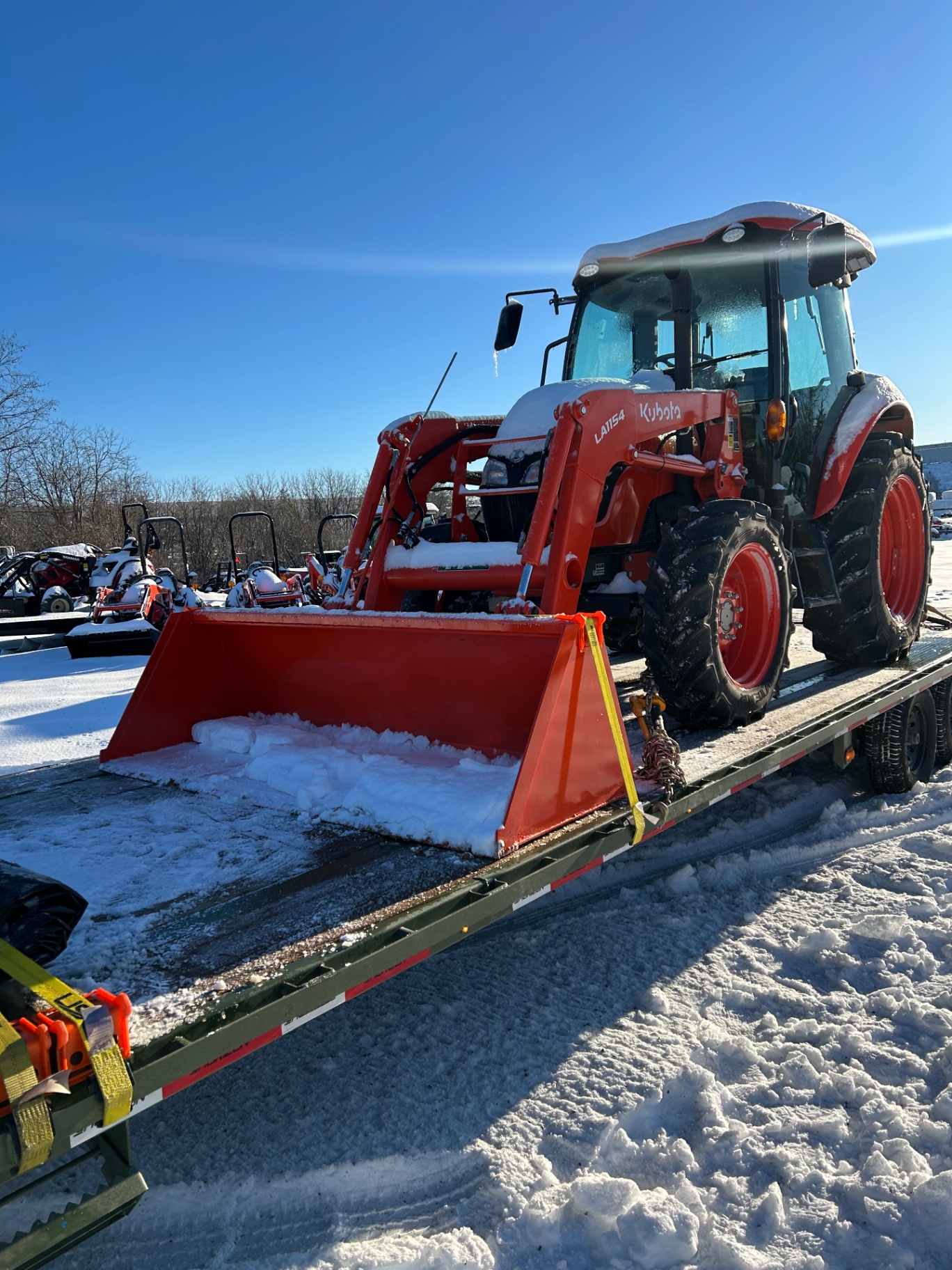 Kubota tractor with loader transported on a flatbed in winter