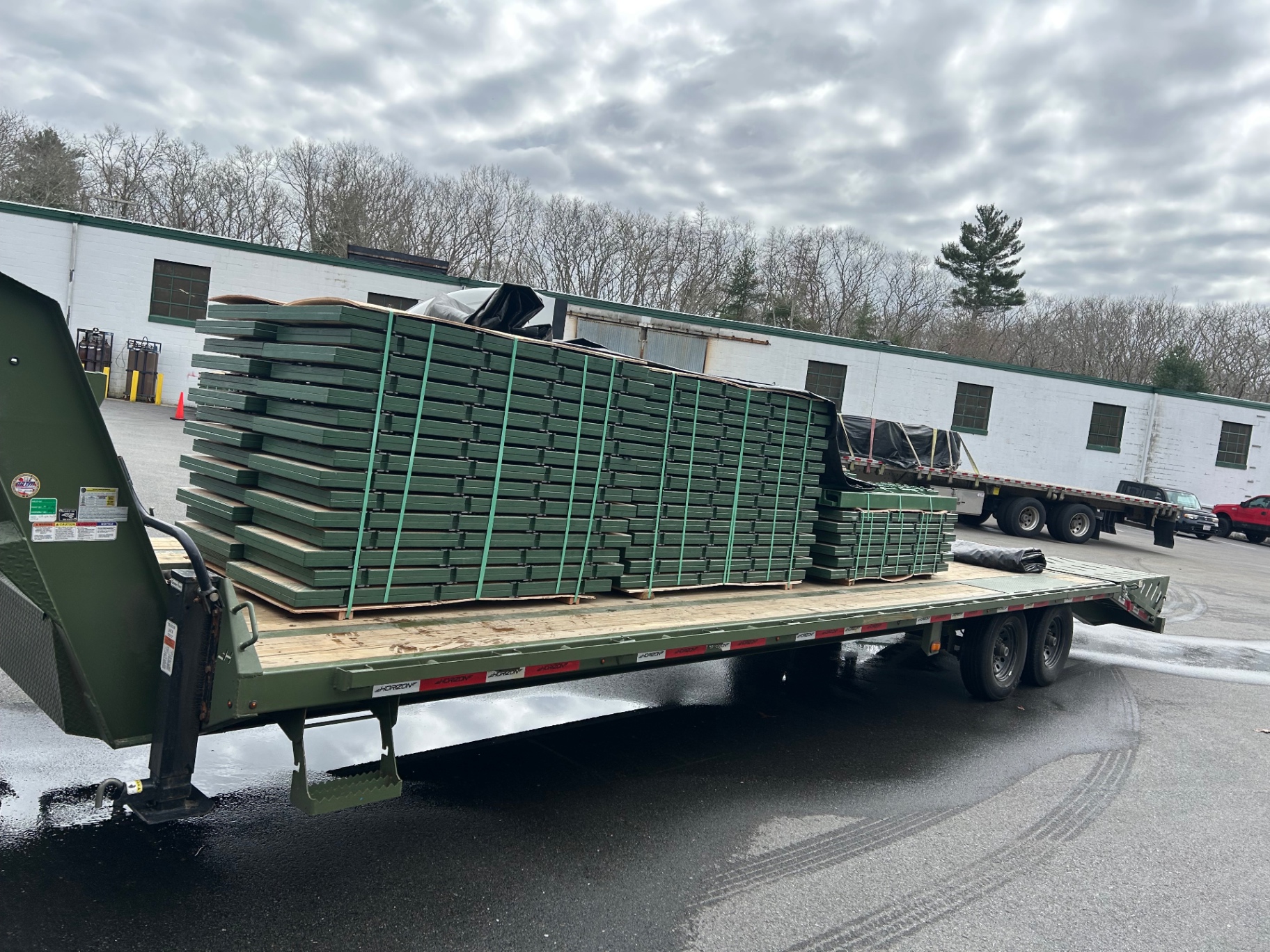 Pallets of green steel racking and building components on a flatbed